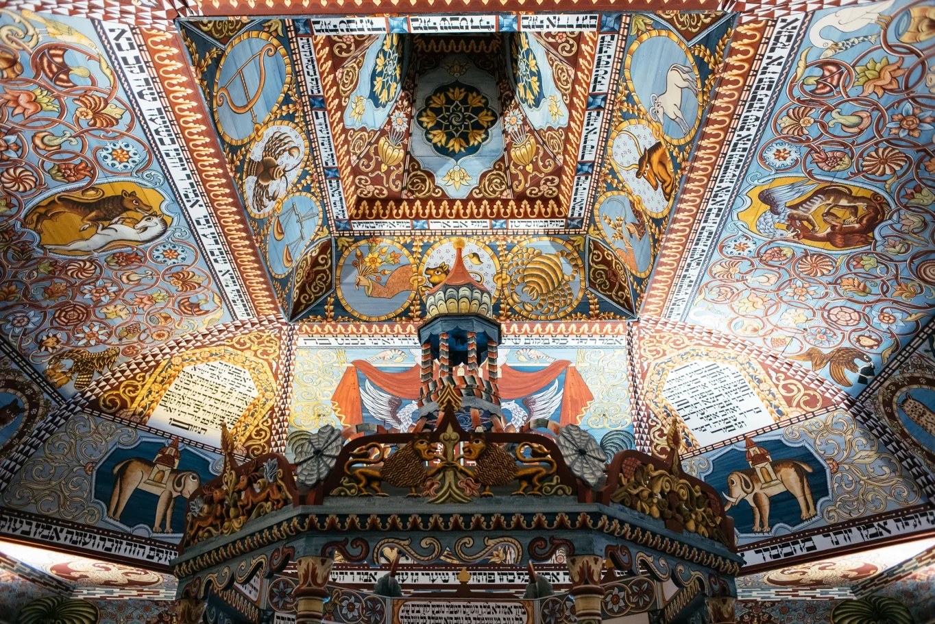 Fragment bogato zdobionego sufitu synagogi. Na całej powierzchni sufitu kolorowe malowidła, głównie w kolorze niebieskim i pomarańczowym.