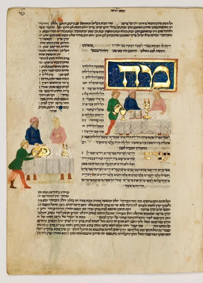 Pożółkła strona z książki. Na niej tekst w alfabecie hebrajskim. W tekst wplecione są 2 kolorowe, podobne ilustracje. Przedstawiają 3 osoby przy stole nakrytym długim obrusem.