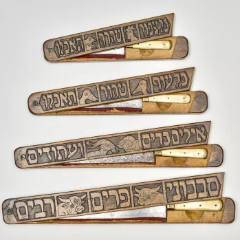 4 noże leżą jeden pod drugim od najmniejszego do największego. Na każdym tekst w alfabecie hebrajskim i głowa innego zwierzęcia.