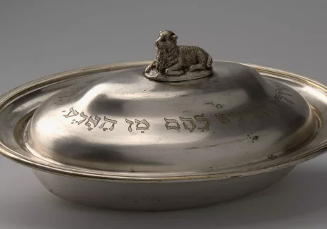 Metal vessel with a round shape with inscriptions. Handle of the lid in the shape of a lying lamb.