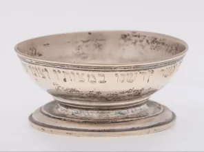 Deep bowl on a short leg. Inside and outside the bowl are inscriptions in Hebrew.